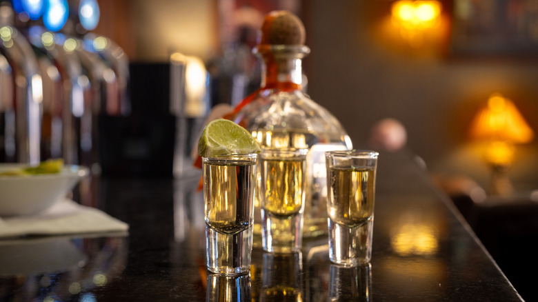 bottle of tequila with poured shots