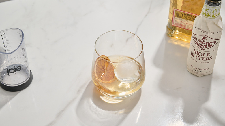 cocktail garnished with a dried orange slice