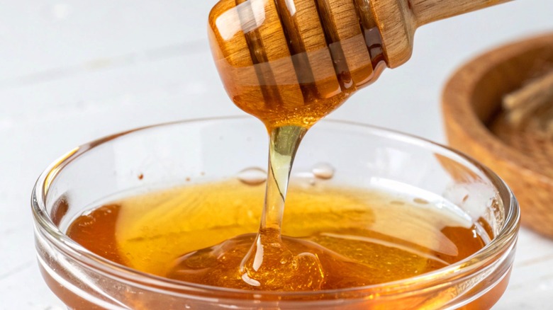 Honey dripping from wooden spoon.