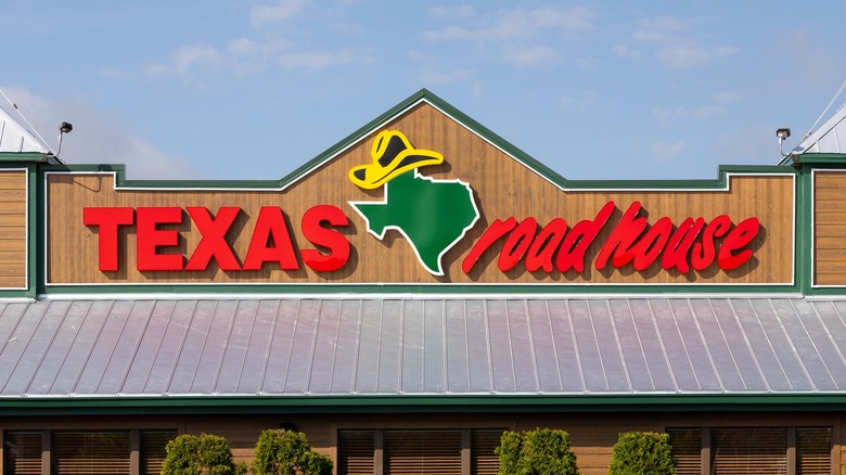 A Texas Roadhouse sign against a blue sky