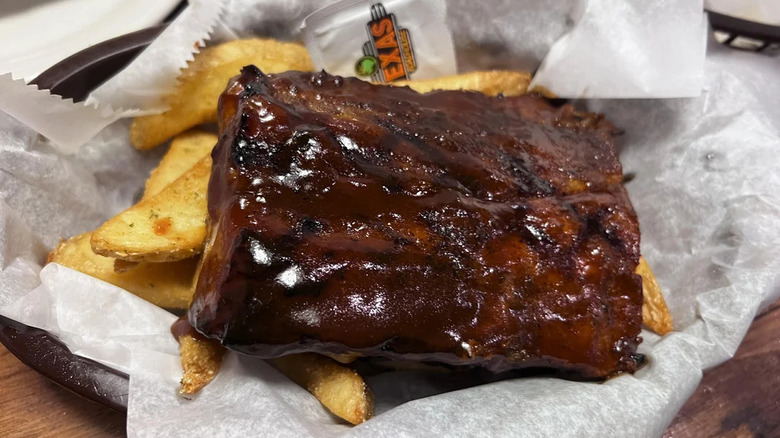 Closeup of Texas Roadhouse ribs in a basket with fries