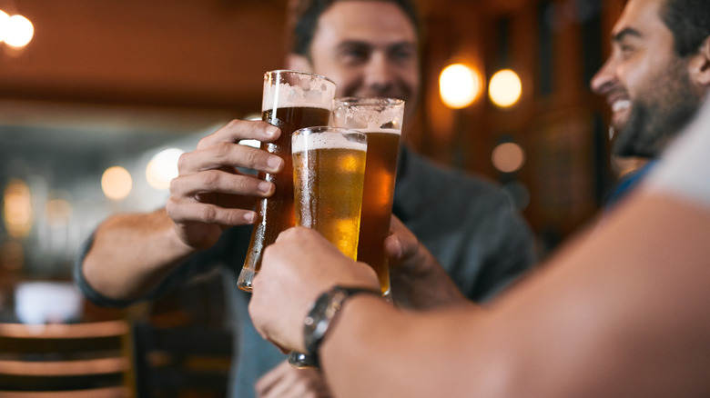 Men holding up glasses of draft beer