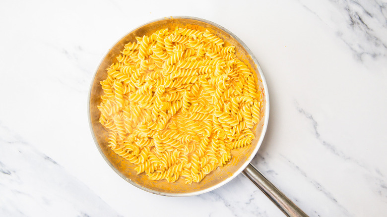 Pasta in pan with sauce.