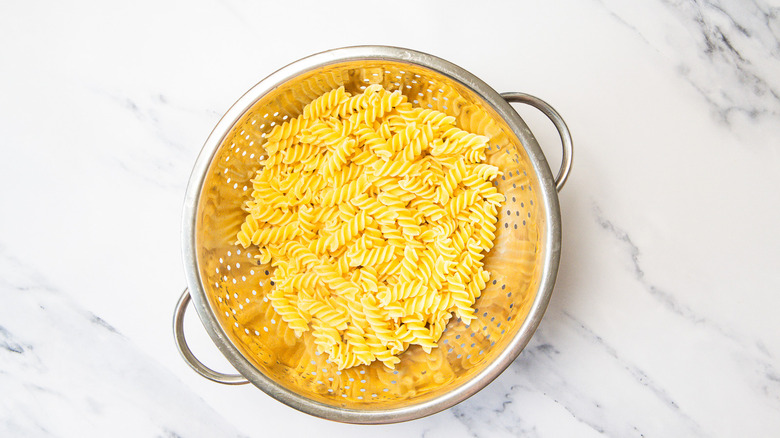 Drained cooked pasta in colander.