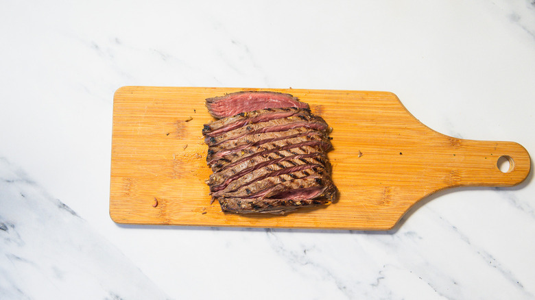 Sliced steak on cutting board