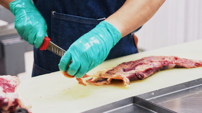 chef removing beef silver skin