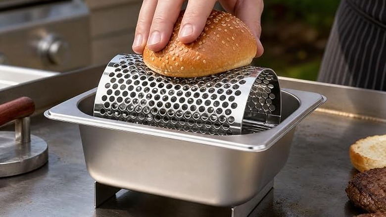 Burgers being cooked with a butter roller on a griddle