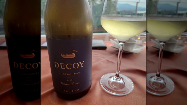 closeup of Decoy Limited Sonoma Coast Chardonnay bottle next to a glass of white wine