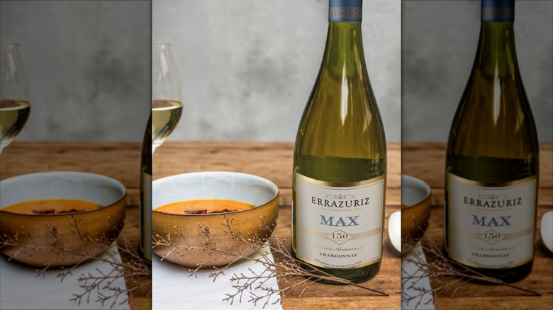 bottle of white wine next to bowl of soup