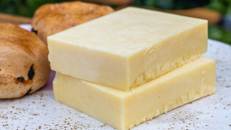 two large blocks of whtie, aged cheddar cheese