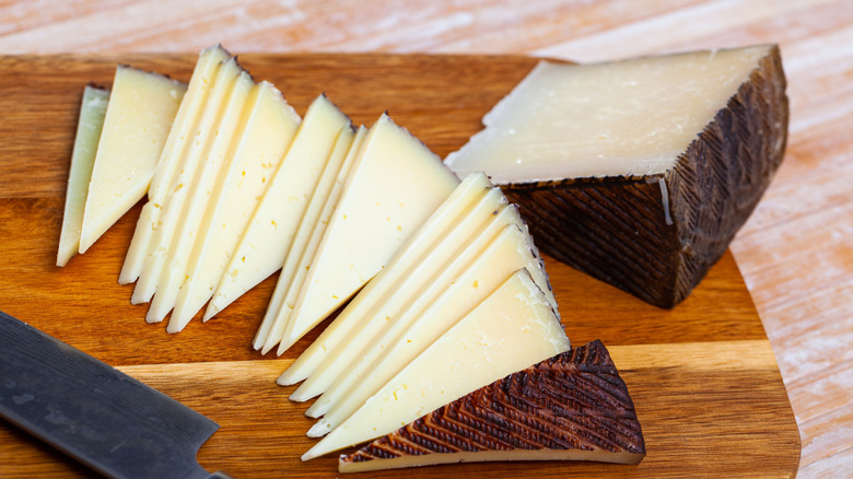 splayed out triangles of semi-hard Manchego on a board