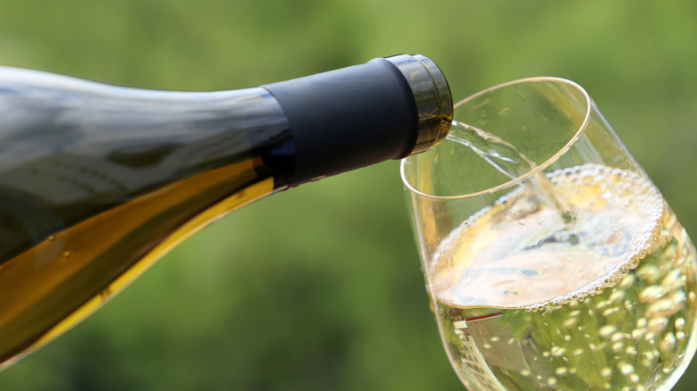 pouring white wine into glass