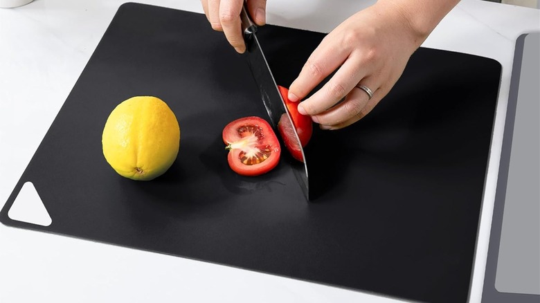 An overview shot of the WK board being used to chop a singular tomato