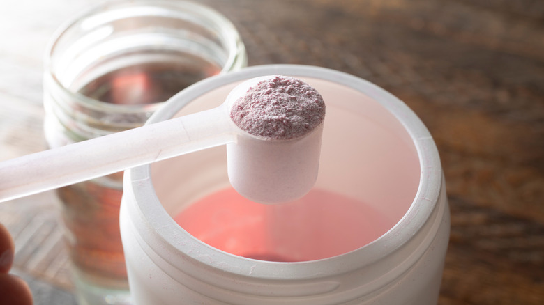 Scoop getting powdered electrolytes out of white container