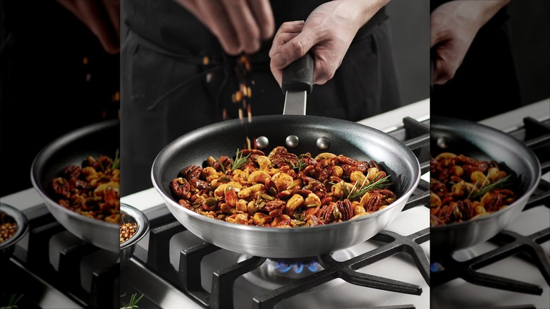 Chef browning nuts and rosemary in Member's Mark aluminum restaurant frying pan