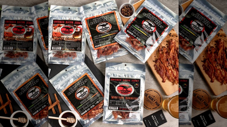 Plastic bags of Manly Man Co. branded bacon jerkies on beige surface