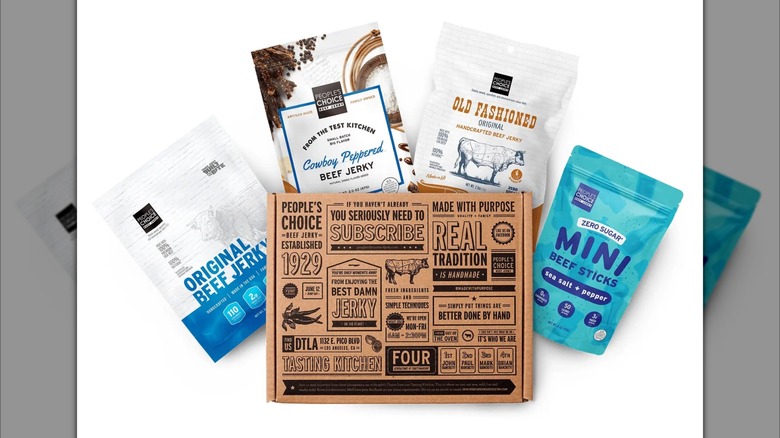 Bags of beef jerky and beef sticks from People's Choice Beef Jerky next to cardboard box on white background