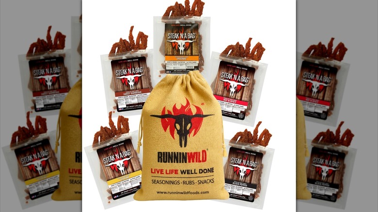 Five bags of beef jerky from Runnin' Wild Foods next to burlap sack with cow skull design and company logo