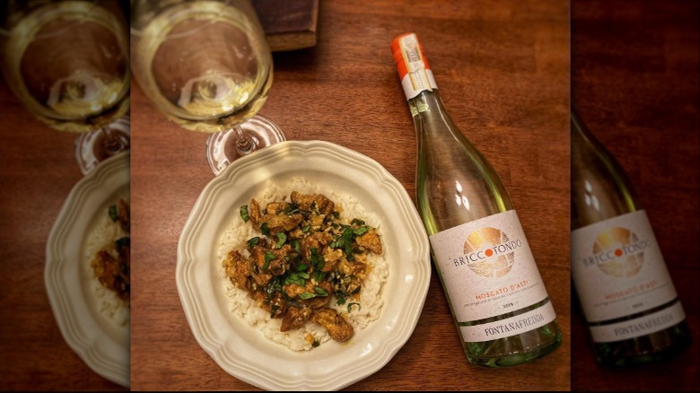 bottle of white wine with a plate with food