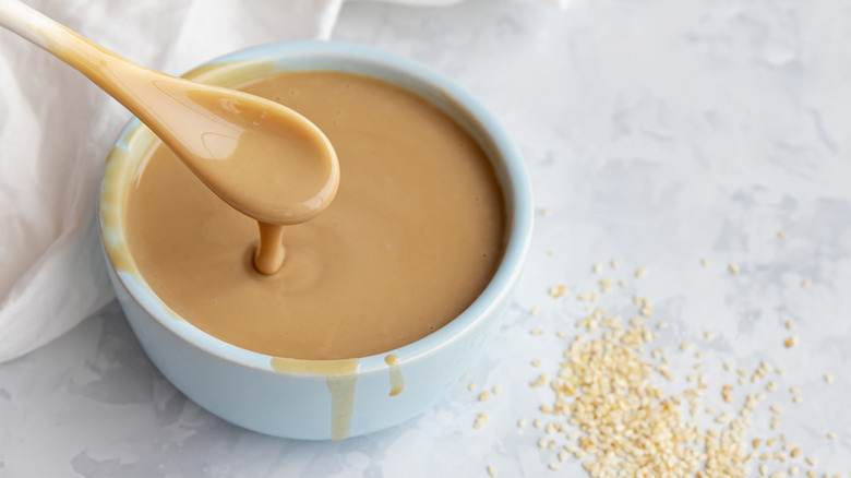Spooning tahini from bowl