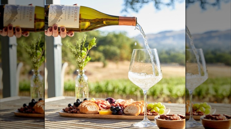 hand pouring white wine into glass