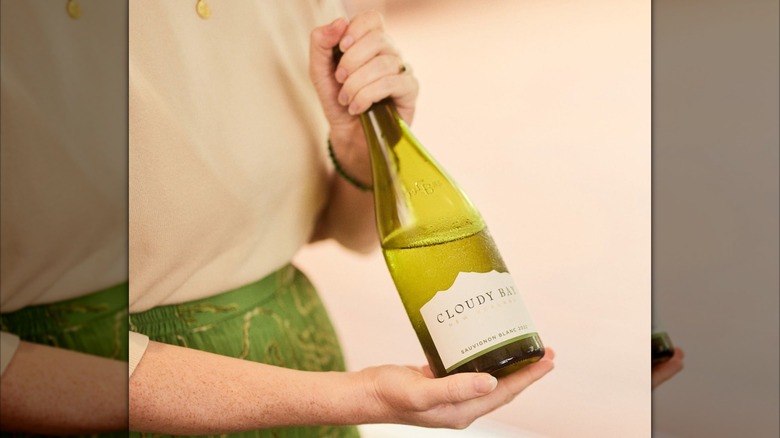 woman holding bottle of white wine