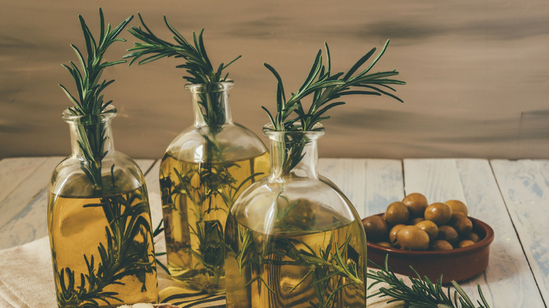 Rosemary infused olive oil in jars with a clove of garlic