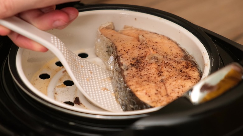 Steamed swordfish filet in steamer basket.