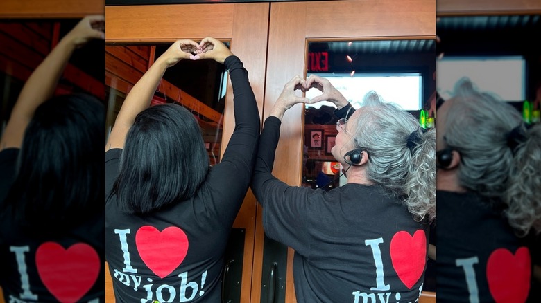 Texas Roadhouse employees with "I love my job!" shirts make hearts with their hands