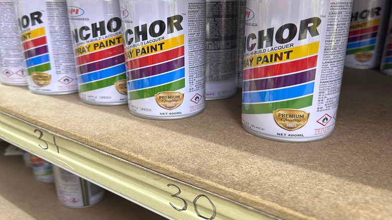 Shelf displaying lacquer spray paint cans at a store
