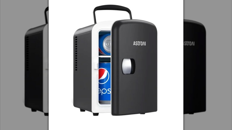 black AstroAI mini fridge with Pepsi cans inside on white background