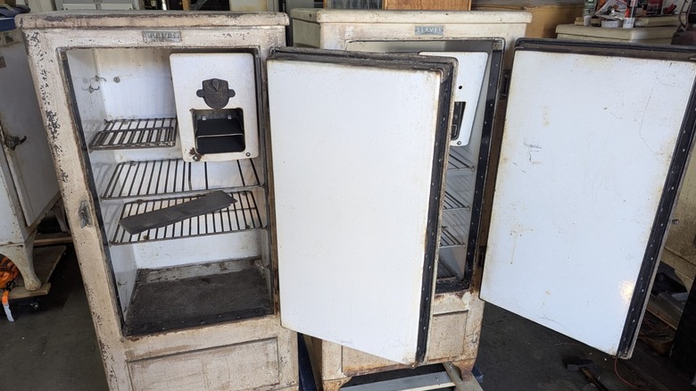 Two heavily worn vintage Servel refrigerators with open doors