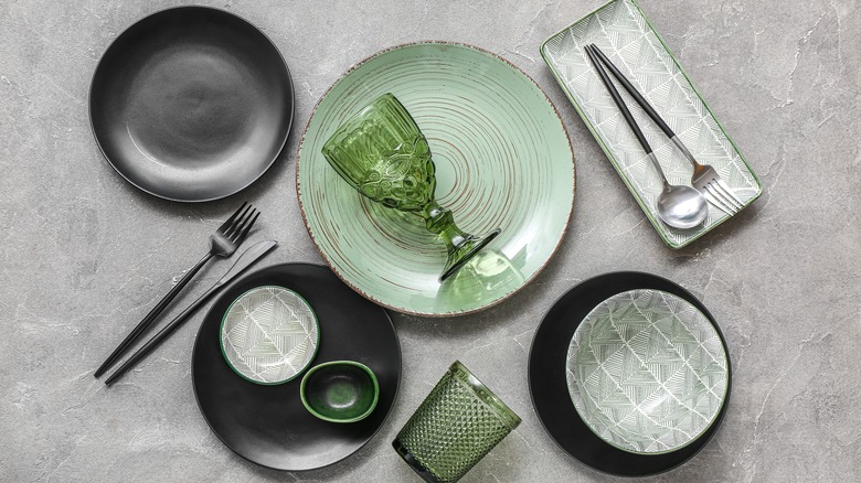 A green and black dinnerware set on a gray background
