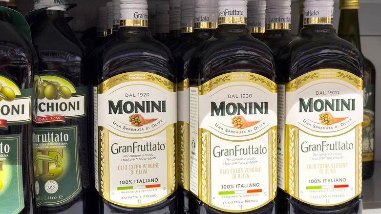 2 brands of Italian premium olive oils lined up on a shelf