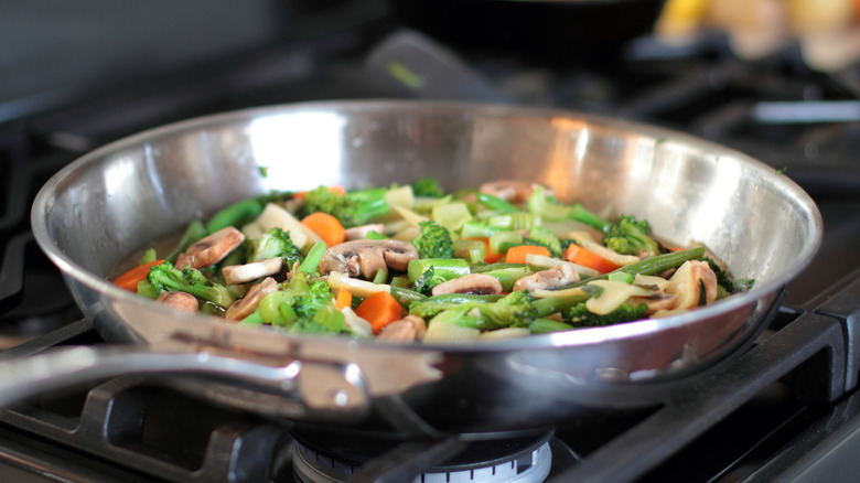 Overcrowded stainless steel pan of vegetables