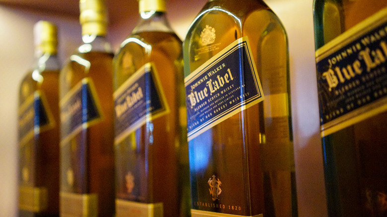 Close up on row of Johnnie Walker Blue Label bottles on shelf.