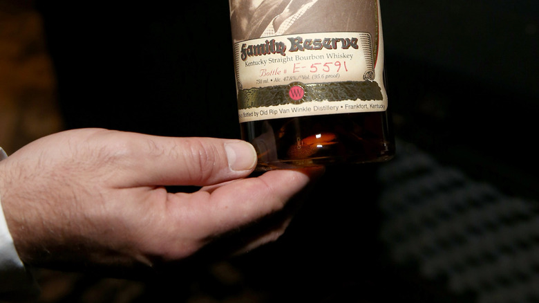 Close up on Pappy Van Winkle bottle's label against blurry background.