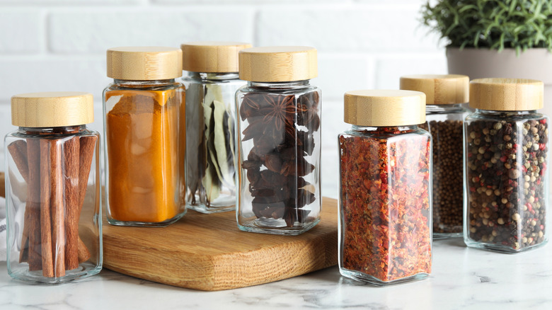 Different spices in glass jars on a kitchen counter