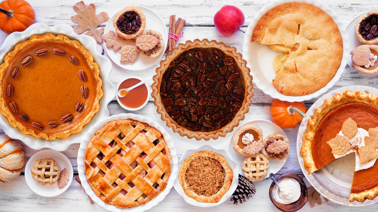 Some Thanksgiving pies on a table with garnishes
