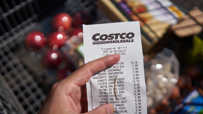 Costco receipt held in front of produce