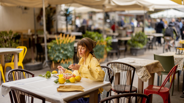 Woman dining at a restaurant alone outdoors