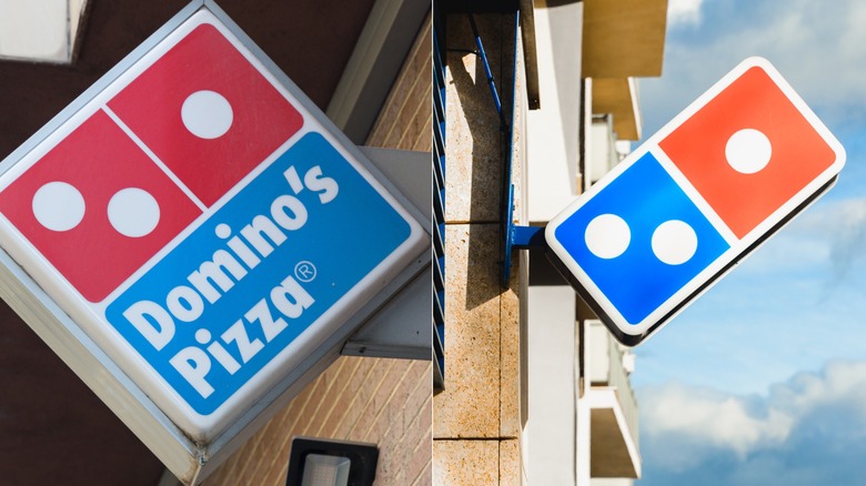 Domino's corporate logo emblem on top of delivery vehicle on city street.