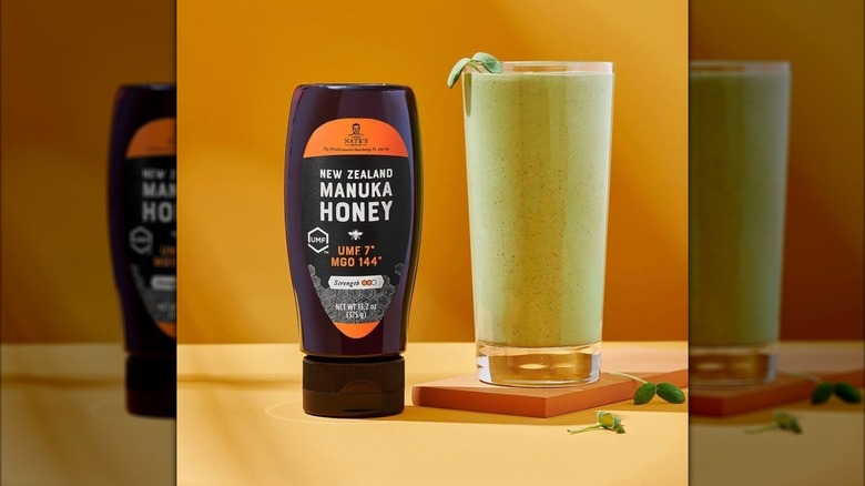 Bottle of New Zealand Manuka honey next to smoothie