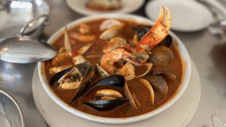 Cioppino in San Francisco at Anchor Oyster Bar in a white bowl with a crab leg