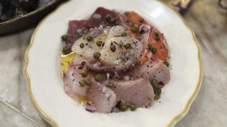 Crudo with capers in a white bowl from a Bay Area seafood restaurant