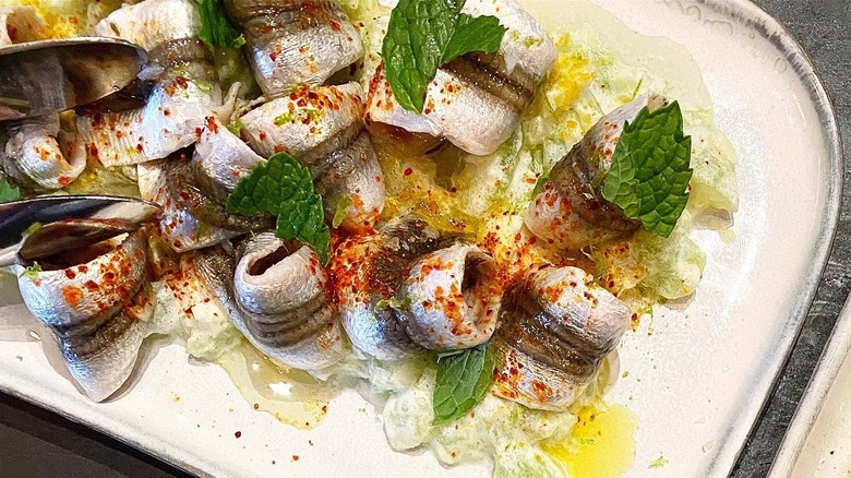 Fish rolls on crema with mint leaves on top at a Bay Area seafood restaurant