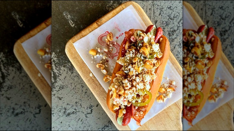 Top-down shot of loaded hot dog on paper and cutting board