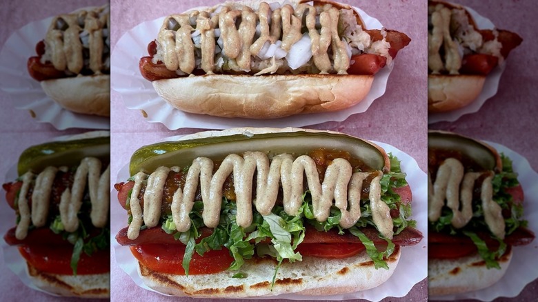 Two loaded hot dogs with heavy sauce drizzle on table at Super Duper Weenie