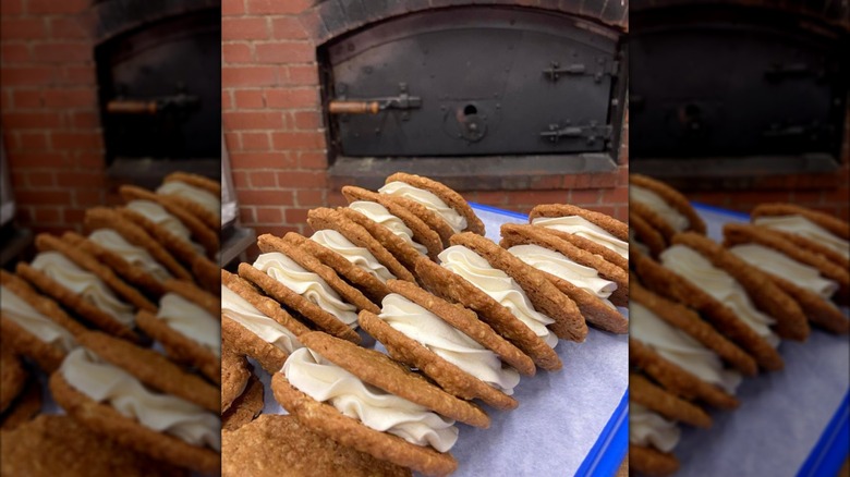 A tray of oatmeal cream pies in front of an old-fashioned bakery oven