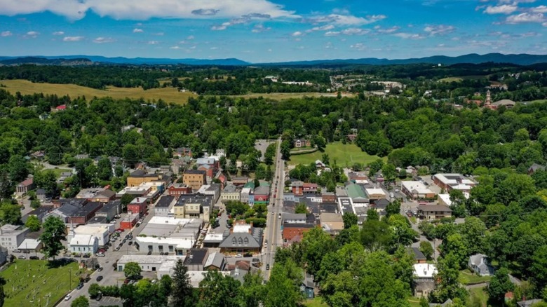 An aerial view of downtown Lewisburg, West Virginia, surrounded by hills, trees, and greenery